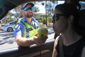 A driver doing a breathalyser test during a police stop