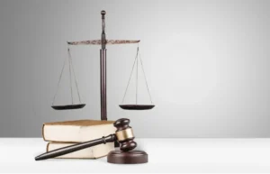 A gavel and scales of justice on legal books.