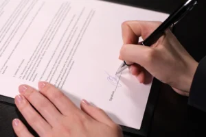 woman puts a fake signature on the fake contract