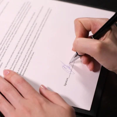 shutterstock_1764571745 woman puts a fake signature on the fake contract