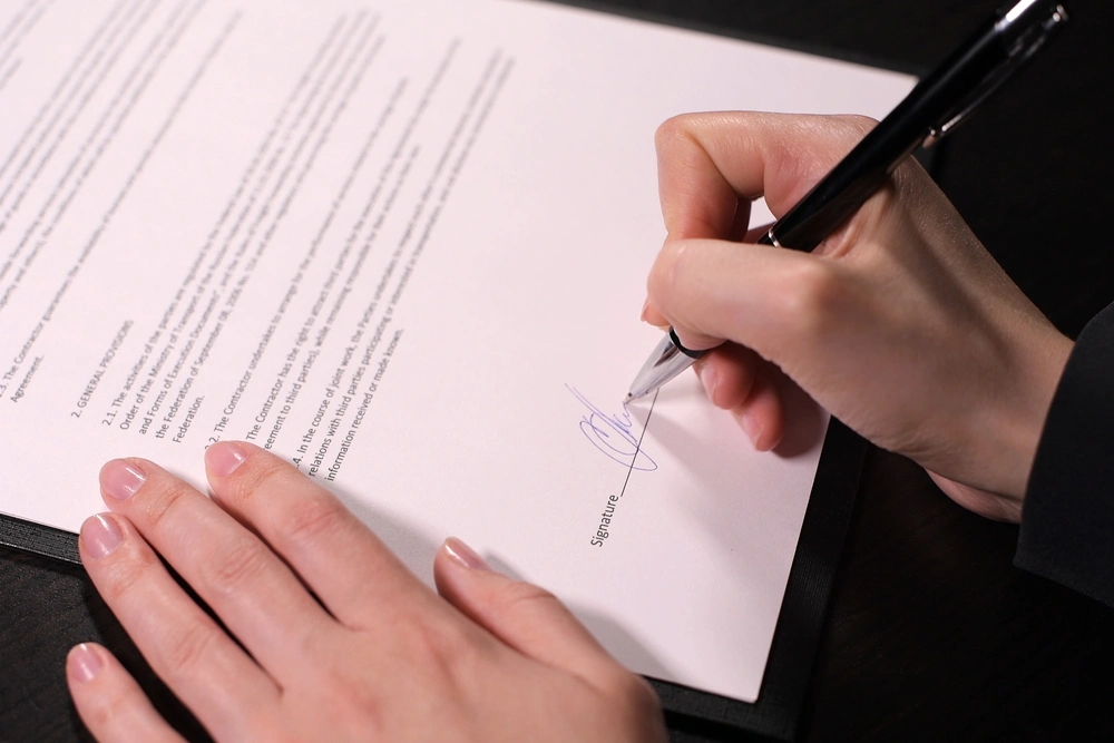 woman puts a fake signature on the fake contract