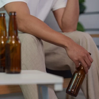 shutterstock_2778043241 Asian man in his 20s struggling with alcoholism at home